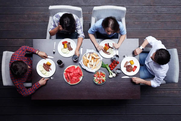4人の友人が夕食を食べ — ストック写真