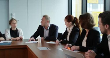 İş ortaklarının toplantıda belge ve fikirleri tartıştığı resim