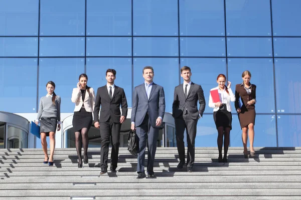 Team of diverse business people at stairs of company office building