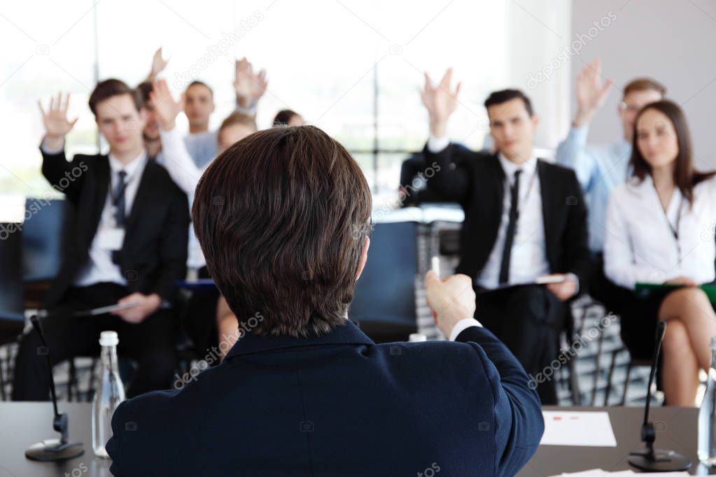 Speaker at business conference and audience asking questions