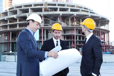 Gökdelenlerin arkaplanındaki planlara sahip mimarlar