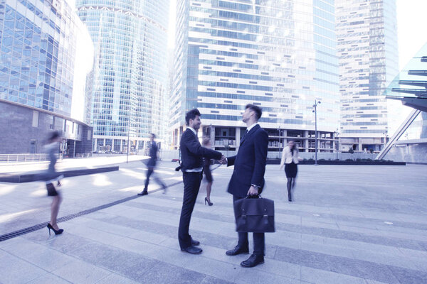 Деловые люди пожимают друг другу руки, заканчивают встречу вне офиса