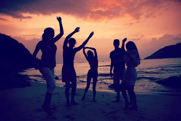 Skupina Šťastných Lidí Tančí Pláži Moře Při Západu Slunce — Stock fotografie