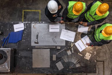 İşçiler ve Yöneticisi güvenlik kask fabrikada belgeleriyle çalışma