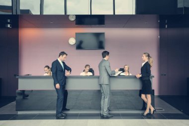Resepsiyondaki ya da ofis binasındaki, oteldeki ya da havaalanındaki iş adamları
