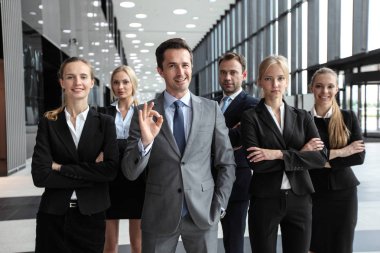 Modern ofis binasında birlikte duran başarılı iş adamlarının portresi