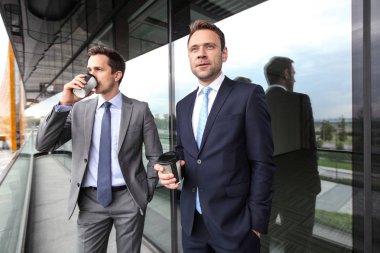 İş adamları ofis binasının balkonunda kahve molası veriyorlar.