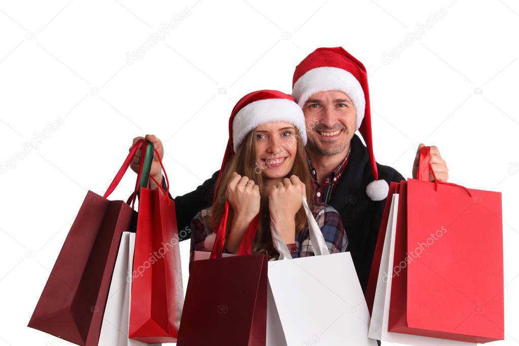 Happy beautiful couple holding many bags with christmas gifts isolated on white background