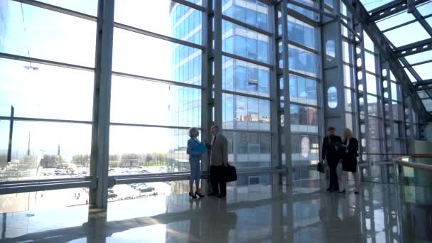 Podnikatelé v moderní skleněné kancelářské budovy lobby