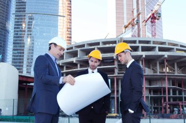 Gökdelenlerin arkaplanındaki planlara sahip mimarlar