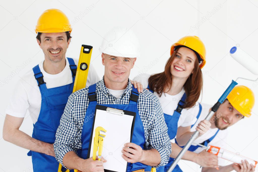 Team of happy smiling workers with tools and contract