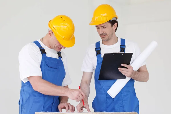 Workers discuss renovation project using digital tablet