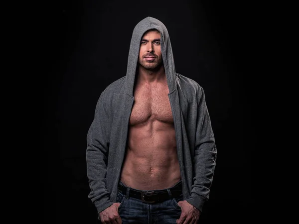 Portrait of brutal muscular man dressed in a grey hoodie isolated on black background — Stock Image Portrait Brutal Muscular Man Dressed Grey Hoodie Isolated Black Background Royalty Free Stock Images