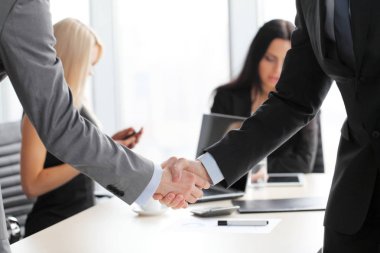 İş adamları el sıkışıyor, toplantıyı bitiriyorlar.