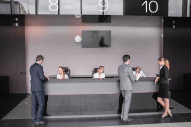 Resepsiyondaki ya da ofis binasındaki, oteldeki ya da havaalanındaki iş adamları