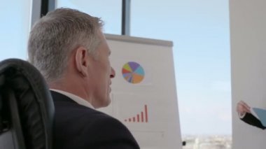 Ofis sunumunda veri mali raporlarını analiz ederek tartışan iş halkı grubu