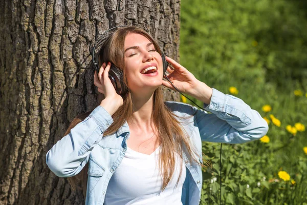Mulher com fones de ouvido no parque — Fotografia de Stock