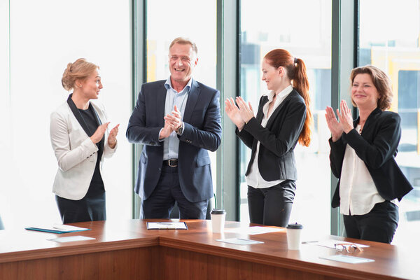 Business group clapping and smiling