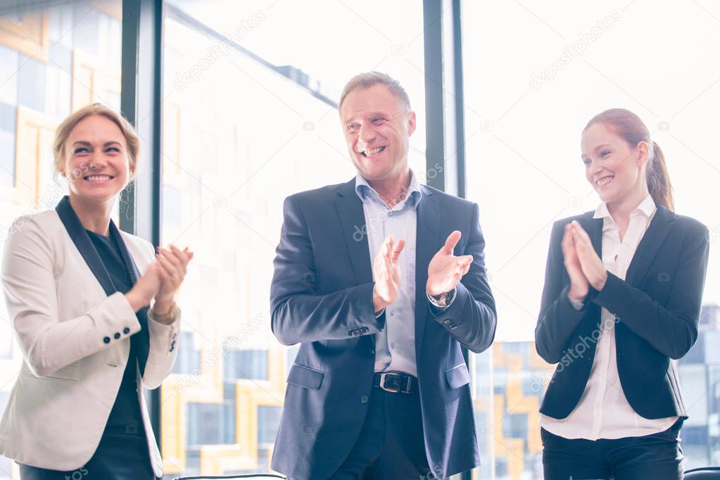 Business group clapping and smiling