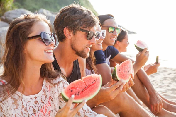 Friends eating watermelon on beach — Stock Photo, Image
