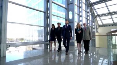 Ofiste koridorda birlikte yürüyen bir grup iş adamı ekibi