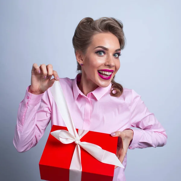 Mujer divertida desempaca regalo — Foto de Stock