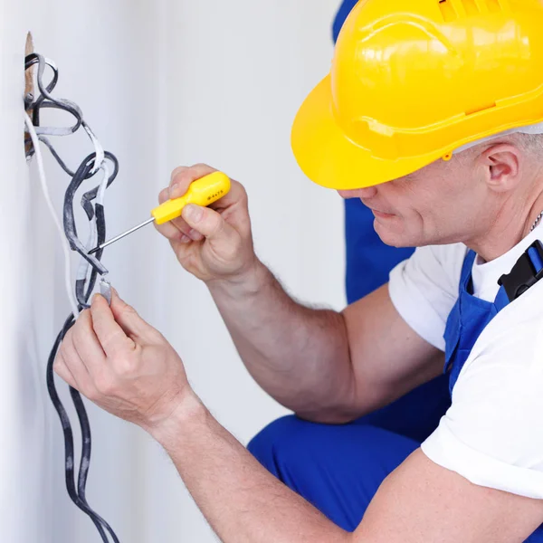 Eletricista descascando fios elétricos — Fotografia de Stock