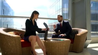 Modern ofis binasında duran iş belgelerini tartışan iş adamları