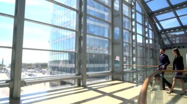 Modern cam ofis koridorunda yürürken iş adamları