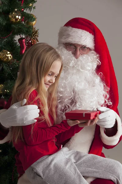 Girl on santa claus knees — Stock Photo, Image