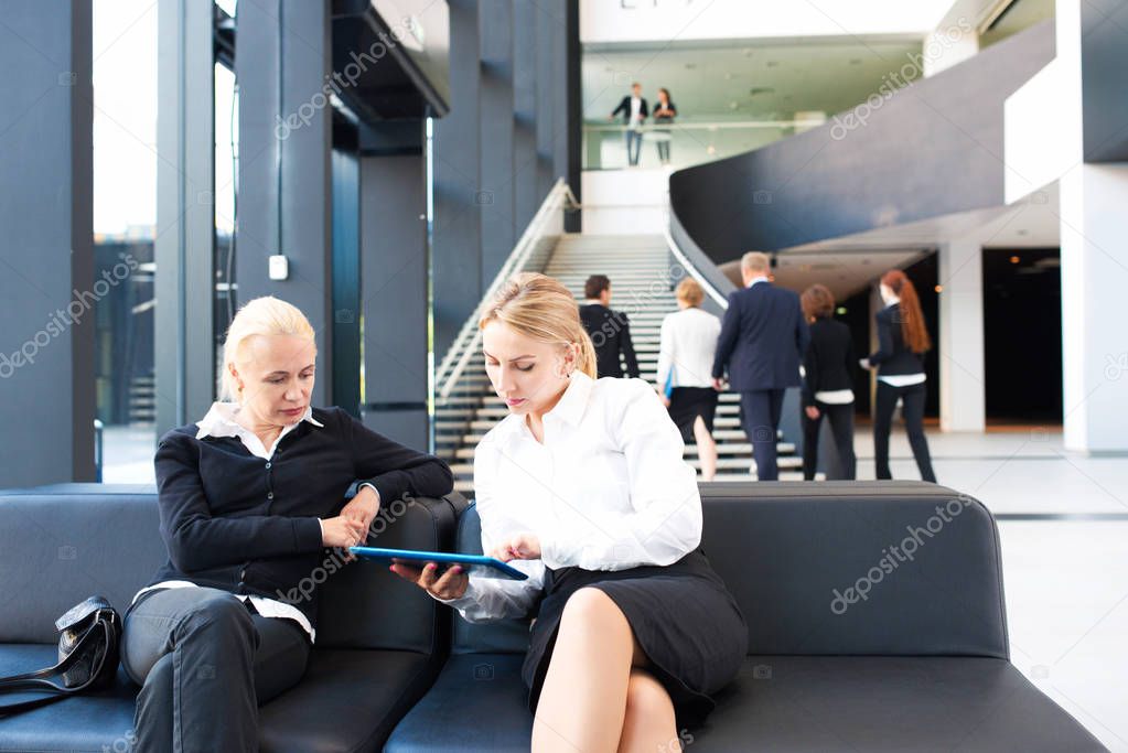 Business women with tablet in lobby