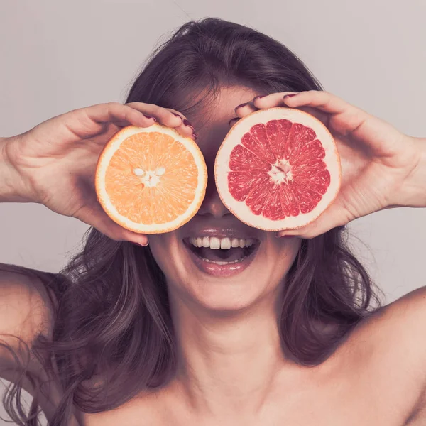 Kobieta z połową owoców cytrusowych — Zdjęcie stockowe