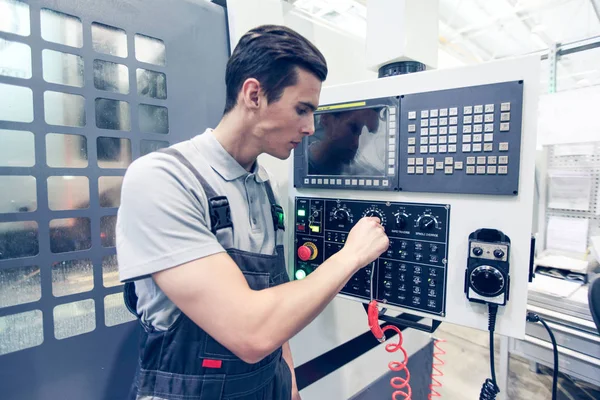 Trabajador pulsando botones en la máquina CNC — Foto de Stock