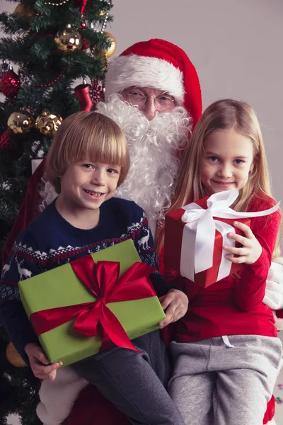 Niños en Santa Claus rodillas — Foto de Stock