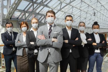 Koruyucu cerrahi maskeler takan ve kolları çapraz, sağlık hizmetleri ve Cvid-19 önleme kavramı ile yan yana duran iş adamları