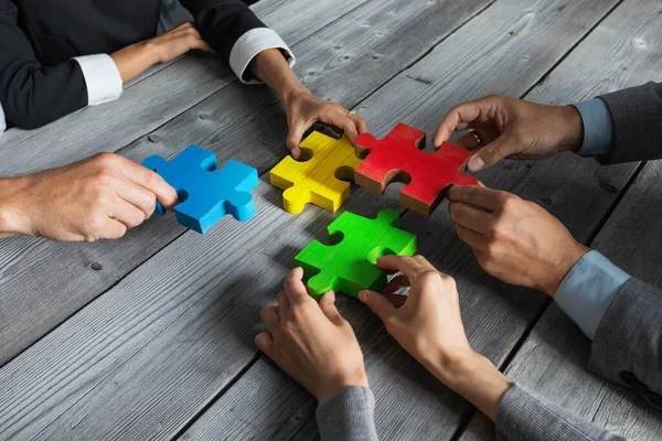 Zakenmensen Team Zitten Rond Vergadertafel Het Assembleren Van Kleur Puzzel — Stockfoto