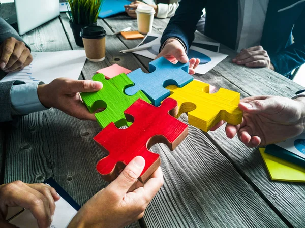 Equipo Gente Negocios Sentado Alrededor Mesa Reunión Montaje Piezas Rompecabezas — Foto de Stock