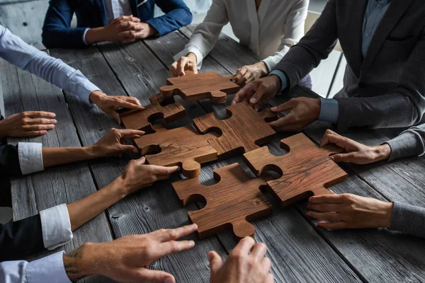 Business People Team Sitting Meeting Table Assembling Wooden Jigsaw Puzzle — Stock Photo, Image