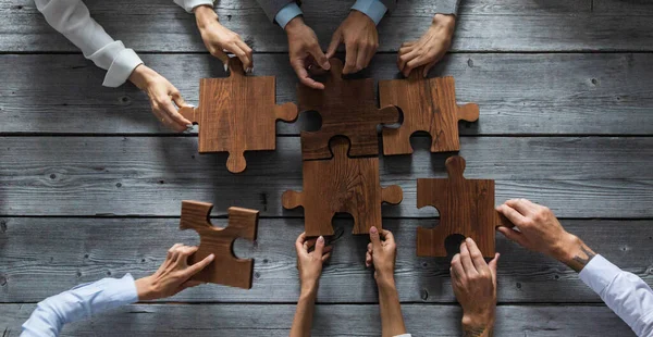 Zakenmensen Team Zitten Rond Vergadertafel Het Assembleren Van Houten Puzzel — Stockfoto