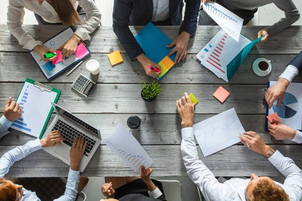 İş yönetimi planlama ekibi konsepti, ofis masasında oturan ve finansal veri raporlarıyla çalışan insanlar.