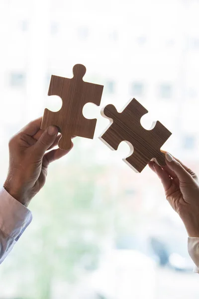 白のパズルピースを持つ男性と女性の手 ビジネス協力問題解決の関係概念 — ストック写真