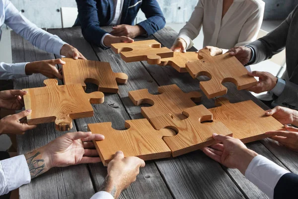 Equipo Gente Negocios Sentado Alrededor Mesa Reunión Montaje Piezas Rompecabezas — Foto de Stock