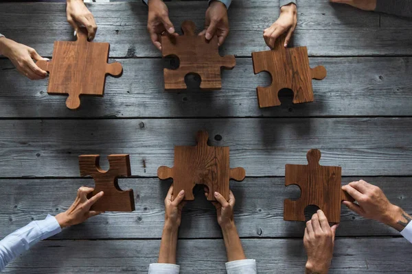 Zakenmensen Team Zitten Rond Vergadertafel Het Assembleren Van Houten Puzzel — Stockfoto