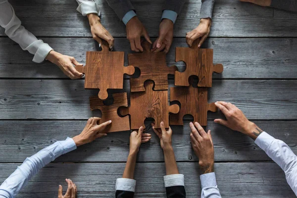 Zakenmensen Team Zitten Rond Vergadertafel Het Assembleren Van Houten Puzzel — Stockfoto