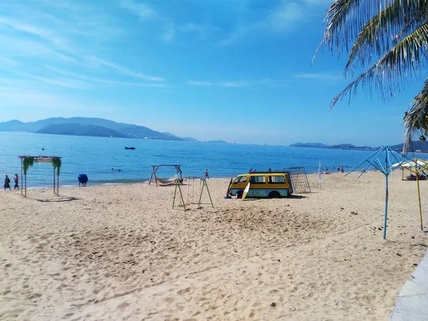 越南芽庄海滩 黄色沙滩 蓝色海洋 夏季天气 热带气候 小船漂浮 巴士站在海岸线上 吊床放松 在海边摇摆 棕榈树叶 — 图库照片