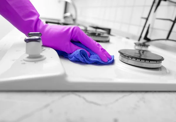 Χέρι γάντια από καουτσούκ καθαρίζει μια σόμπα αερίου κουζίνα. — Φωτογραφία Αρχείου