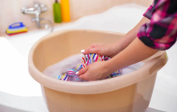Womens handen wassen van kleren in het bekken. — Stockfoto