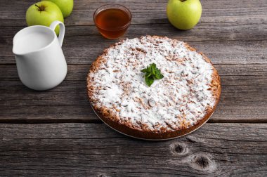 Ev yapımı elmalı turta. Ahşap masaya yatıyor.