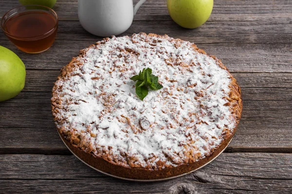 Ev yapımı elmalı turta. Ahşap masaya yatıyor.