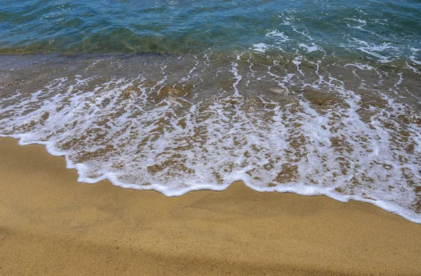 Arena húmeda en la playa. Una parte del mar es visible . — Foto de Stock